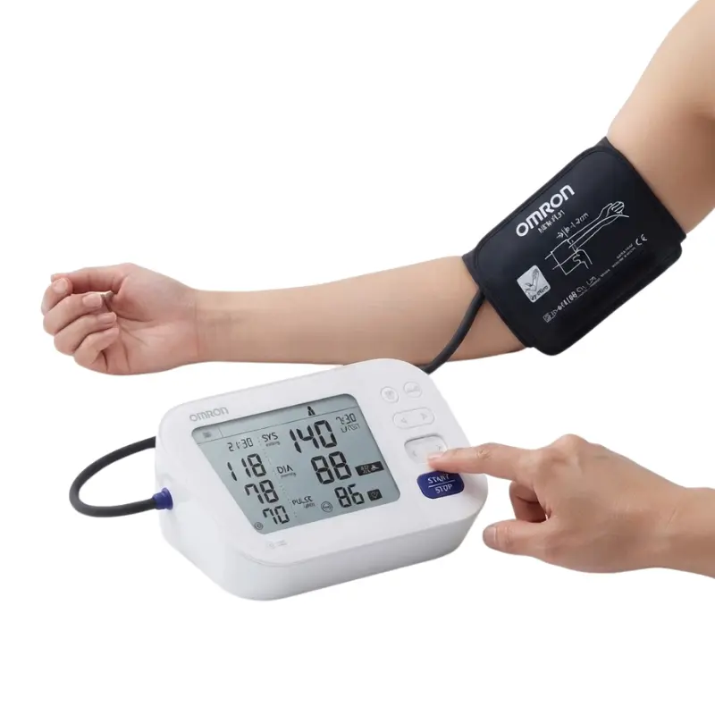 Paciente con el manguito del tensiómetro Omron colocado en el brazo y pulsando el botón de inicio del monitor digital.