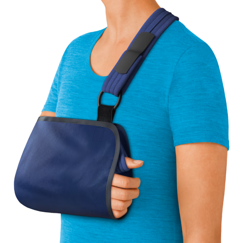 Persona con camiseta azul lleva colocado el cabestrillo Actimove Mitella Talla M para la inmovilización del brazo.