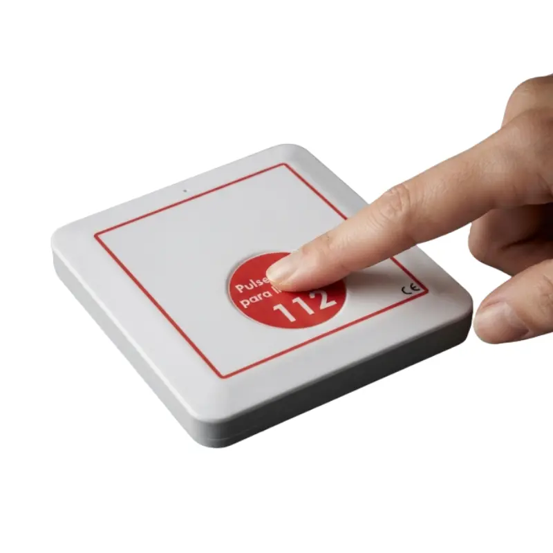Dedo pulsando el botón rojo de emergencia con la inscripción 112 de un dispositivo de llamada automática asistida.