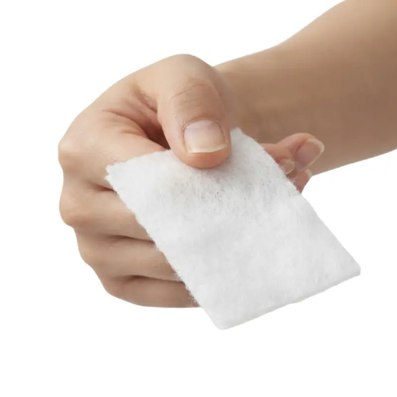Mano sosteniendo un filtro antipartículas blanco y rectangular para equipos de terapia respiratoria ResMed sobre fondo blanco.