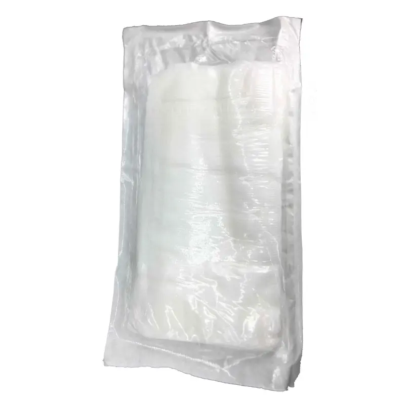 Apósito quirúrgico estéril de gran tamaño empaquetado en una bolsa de plástico transparente sobre fondo blanco.