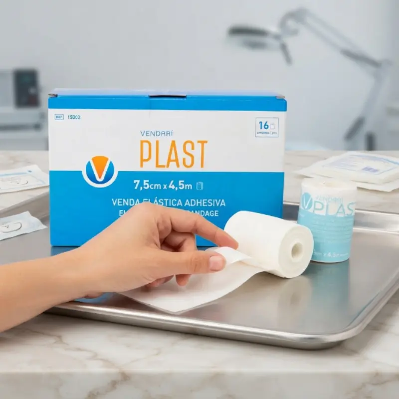Caja de vendaje Vendari PLAST y rollo sobre una bandeja quirúrgica metálica en una clínica.