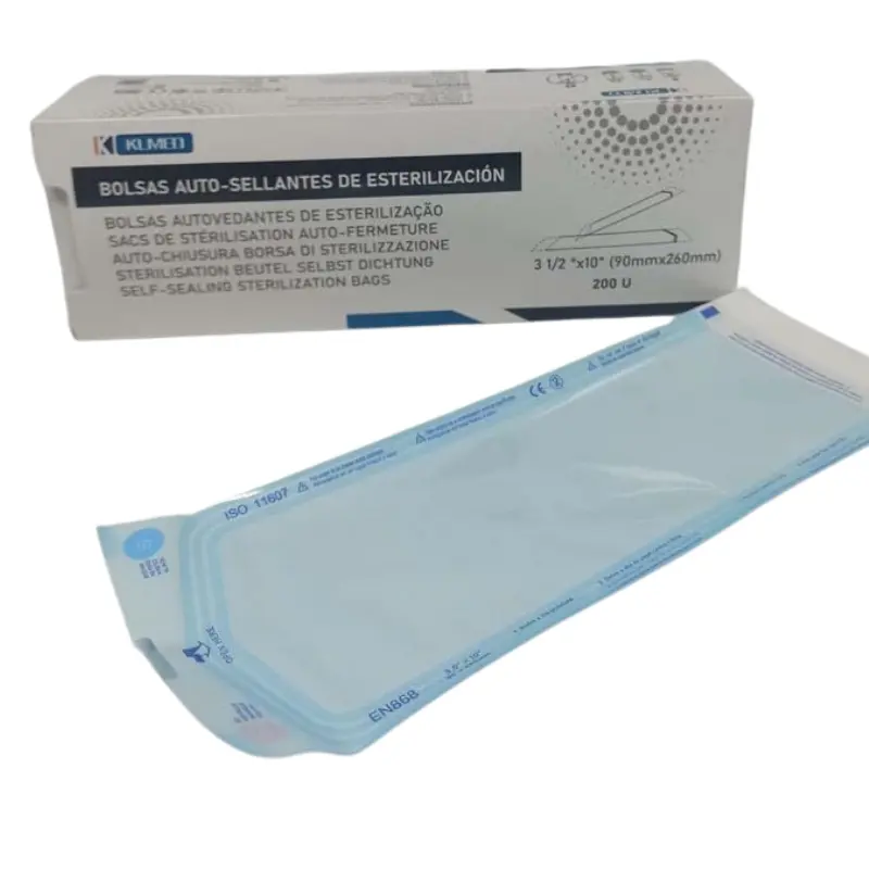 Caja de cartón y bolsa auto-sellante de esterilización Klmed de 90x260 mm sobre una superficie blanca.