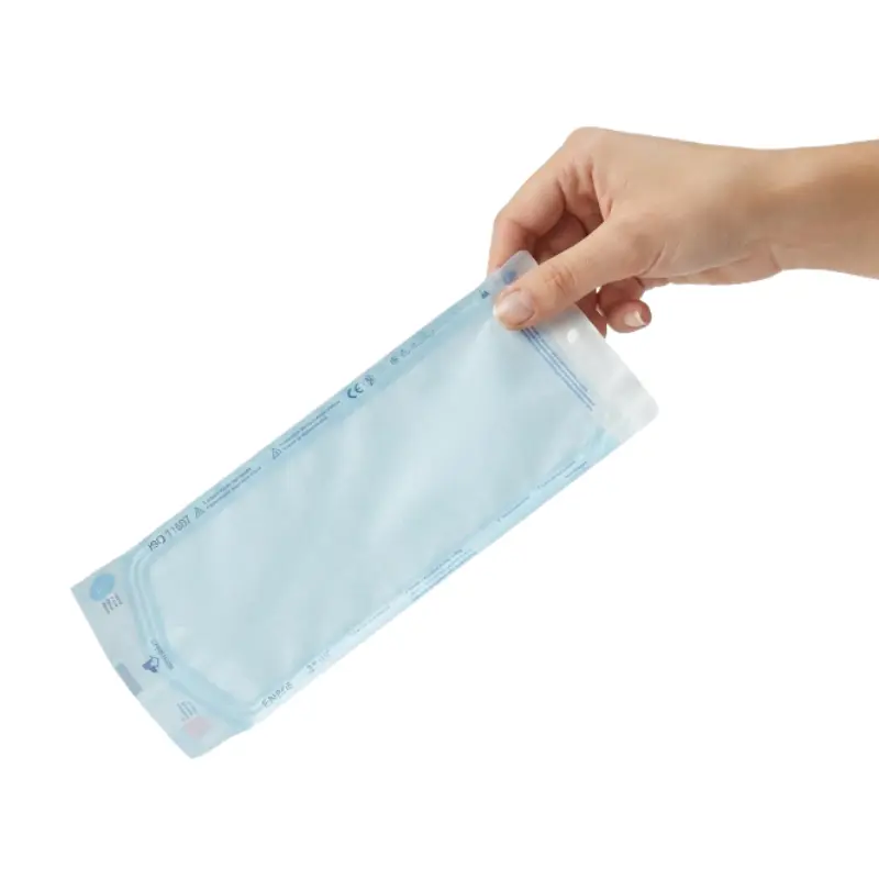 Mano de una persona sosteniendo una bolsa auto-sellante de esterilización Klmed de 90x260 mm aislada.