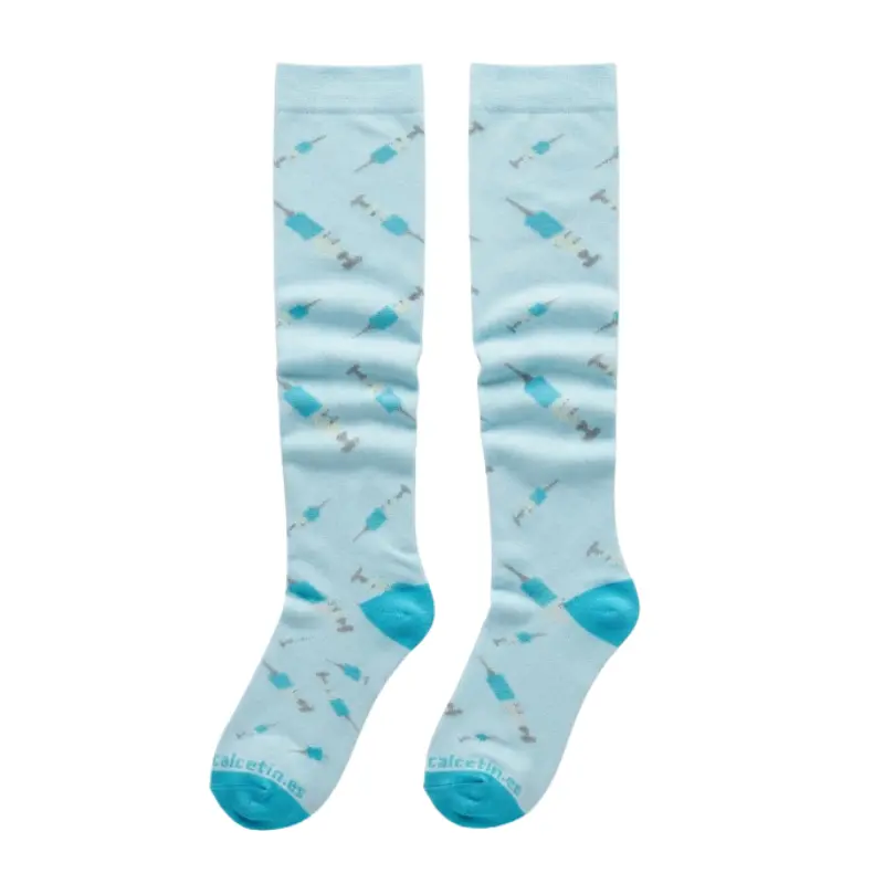 Par de calcetines compresivos de color azul claro con un estampado repetido de jeringas en tonos azules y grises.