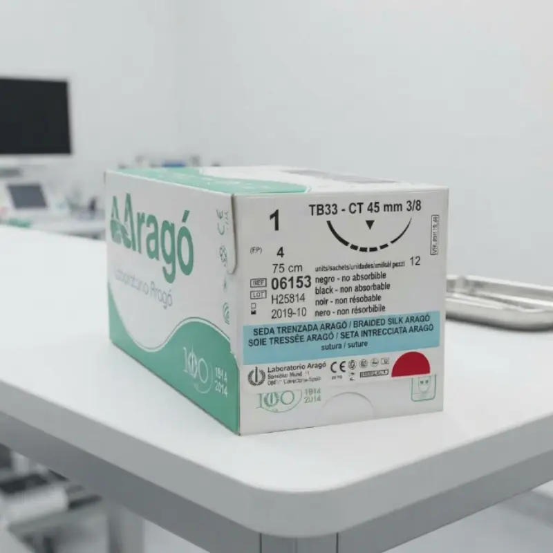 Caja de sutura no absorbible de seda Aragó situada sobre una mesa blanca en una consulta médica luminosa.