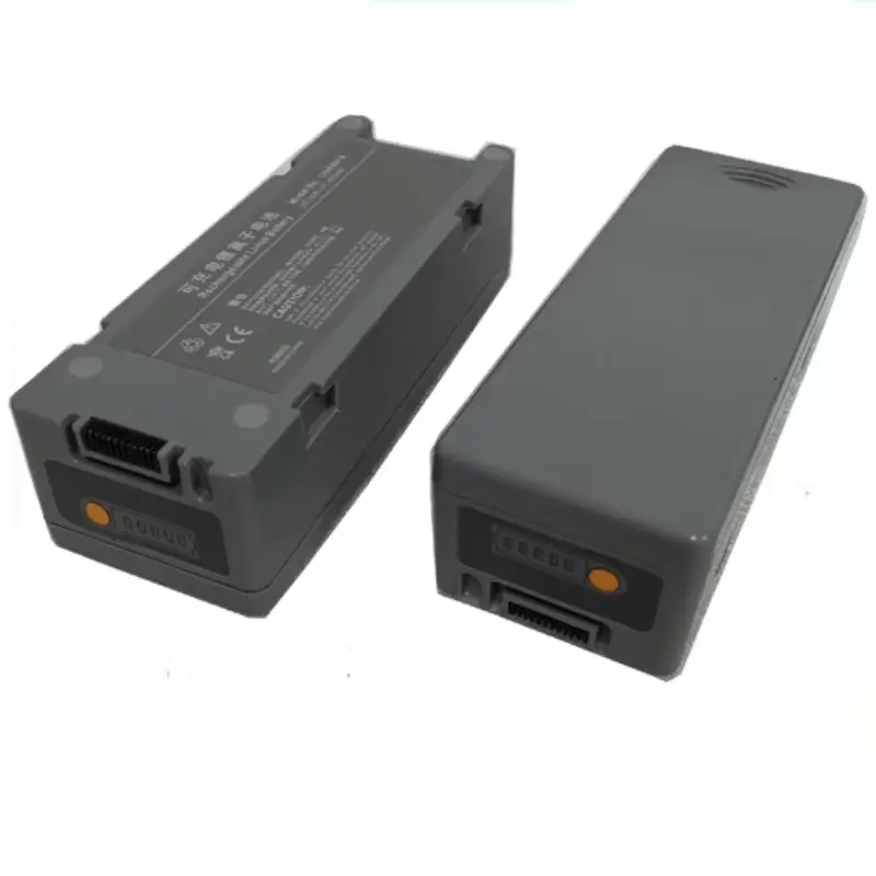 Dos baterías de iones de litio Mindray D6 de color gris dispuestas en ángulo sobre una superficie blanca.
