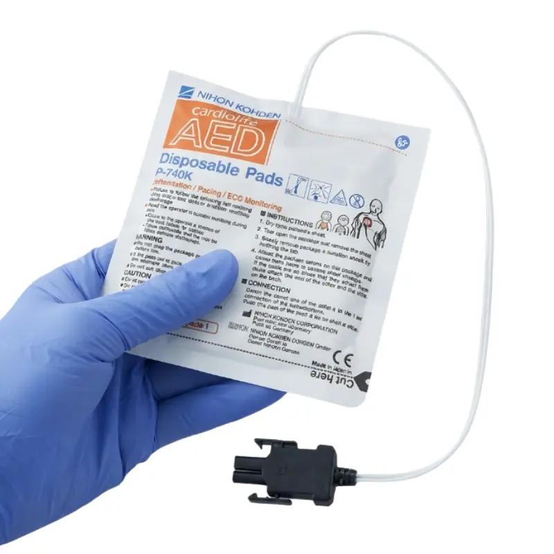 Mano con guante azul de nitrilo sosteniendo el envase sellado de unos electrodos Nihon Kohden Cardiolife.