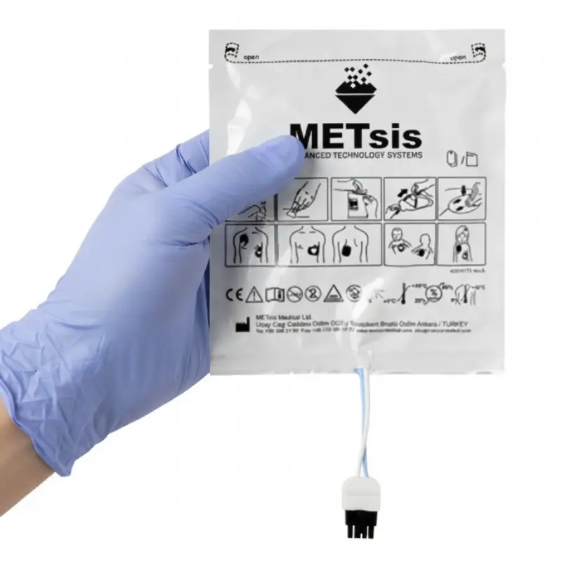 Mano con guante clínico azul sosteniendo el reverso del empaque de electrodos pediátricos Life-Point Pro.