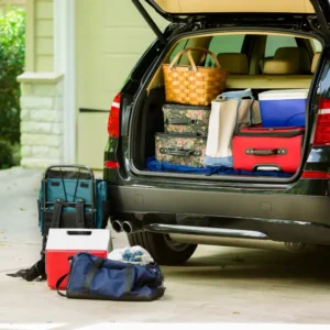 Maletero de un coche abierto y lleno de equipaje para las vacaciones de verano