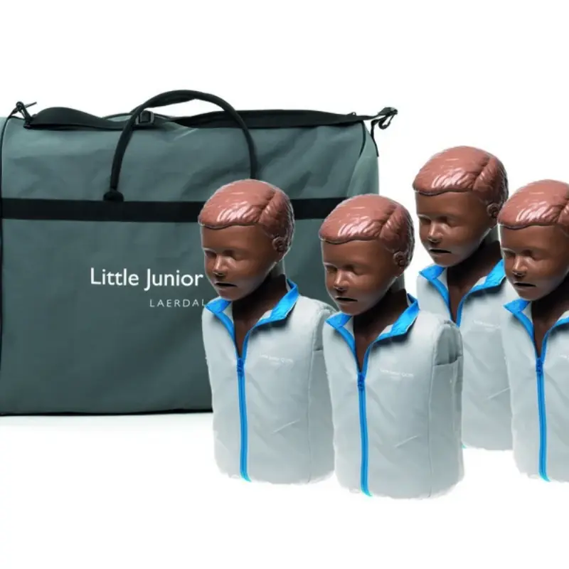 Cuatro maniquíes pediátricos de RCP Laerdal Little Junior QCPR de piel oscura colocados en formación frente a una bolsa de transporte gris.