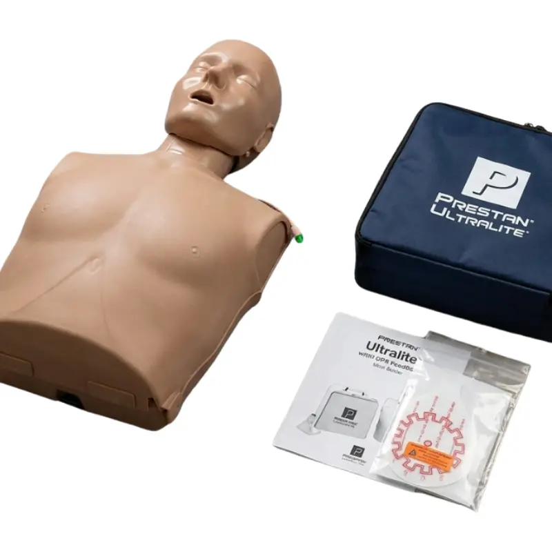 Maniquí de RCP Prestan Ultralite de piel oscura junto a una bolsa de transporte azul, manual y kit de accesorios.