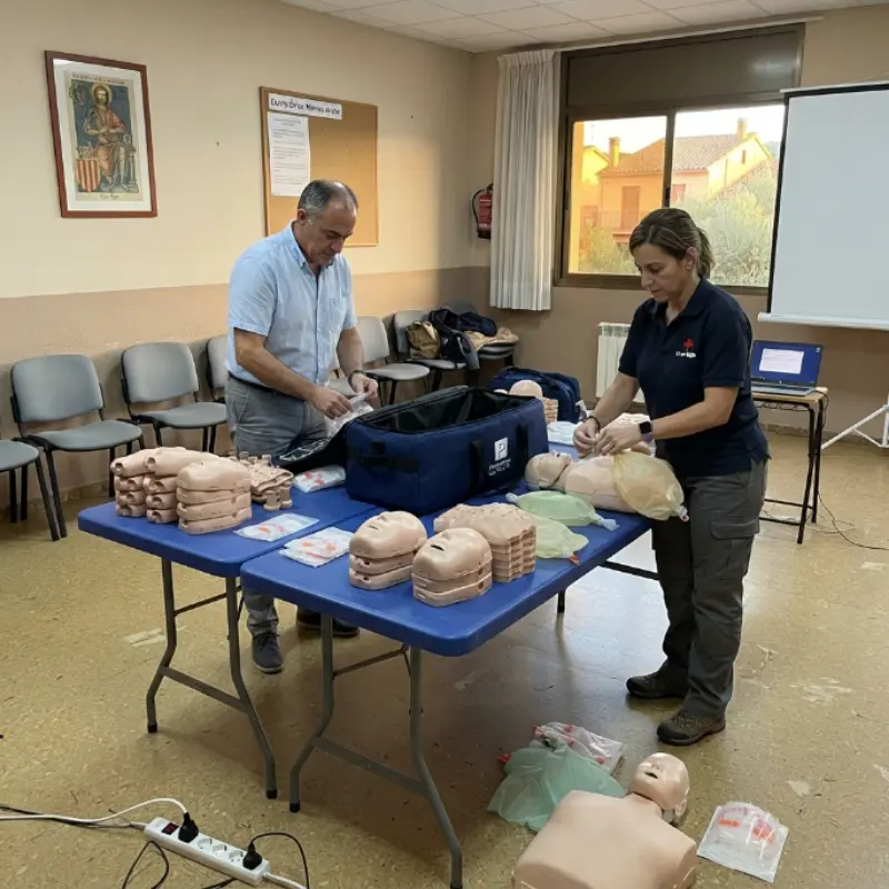 Personal en una sala de formación organizando y preparando los componentes del kit de maniquíes de RCP Prestan Ultralite sobre mesas.