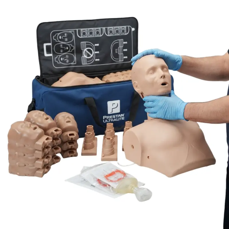 Instructor con guantes azules realizando maniobras de RCP sobre el torso del maniquí Prestan Ultralite junto a la bolsa de transporte.