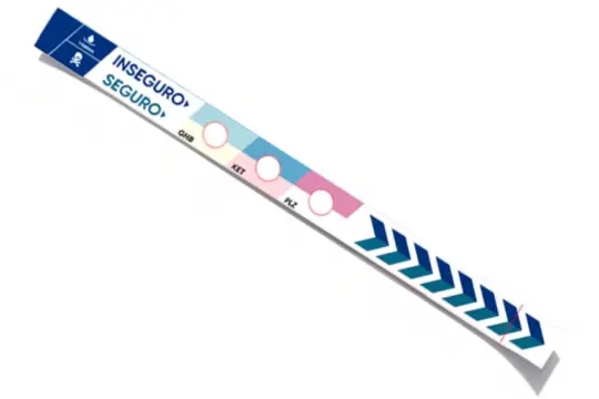 Pulsera detectora de drogas abierta en plano longitudinal mostrando las tres zonas circulares de prueba para GHB, ketamina y flunitrazepam.